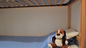 A bunk bed with a blue mattress and a stuffed dog toy on the lower bunk. - Calm mountain corner studio, 4 people, parking, Risoul 1850 (Risoul)