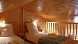 A cozy cabin-style room with two beds, wooden walls, and a sloped ceiling. - 2 rooms + mezzanine in Valmorel, 5 pax, balcony, linens and cleaning included (Valmorel)