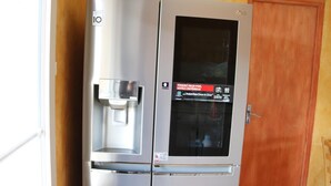 A stainless steel refrigerator with a water dispenser and a glass door.