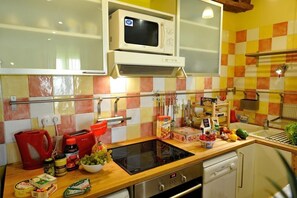 A kitchen with a microwave, stove, and various food items on the counter. - B3DD Honeymoon (París)