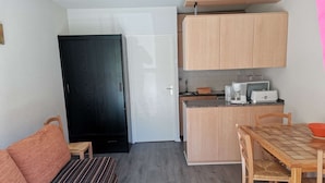 Una cocina funcional con armarios de madera, una mesa de comedor y un sofá.