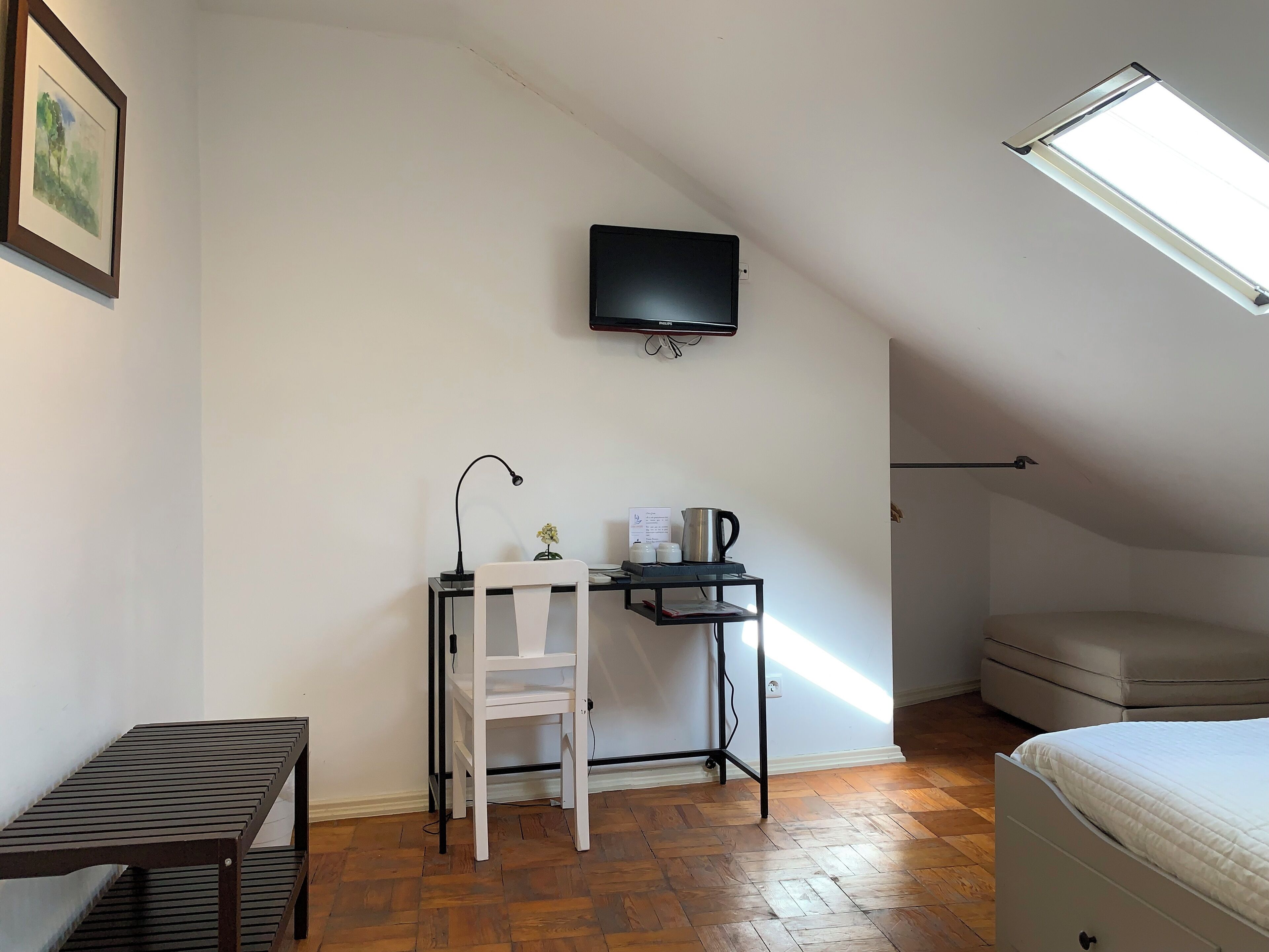 A small, tidy room with a desk, chair, and a bed.