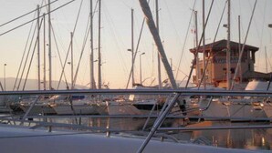 A marina with multiple boats docked, a control tower, and a building with signage. - Ground Floor Apartment Near Port Santa Lucia with Terrace and Garage (Saint-Raphaël)