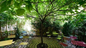 A circular outdoor seating area with a central tree surrounded by benches. - A1G Dreaming (París)