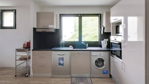 A compact kitchen with a washing machine, a microwave, and a sink.