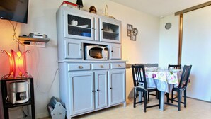 Un espacio habitable pequeño con kitchenette, una mesa de comedor y sillas.