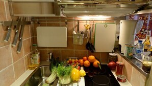 Uma cozinha equipada com pia, fogão e diversos utensílios e eletrodomésticos.