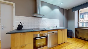 A modern kitchen with a dishwasher, oven, and a window with a view of buildings. - lacour ac 160m2 city center  4br3bth (Colmar)