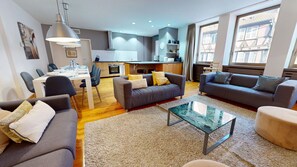 A modern living room with grey sofas, a glass coffee table, and a dining area with a white table and chairs. - lacour ac 160m2 city center  4br3bth (Colmar)