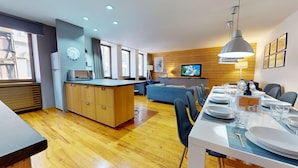A modern hotel room with a kitchen area, dining table set for four, and a living area with a sofa and television. - lacour ac 160m2 city center  4br3bth (Colmar)