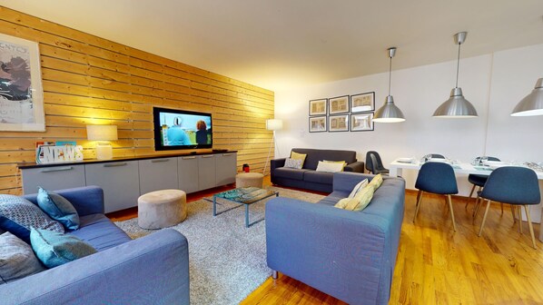 A modern living room with a flat-screen TV, sofas, a coffee table, and a dining area with chairs and a table. - lacour ac 160m2 city center  4br3bth (Colmar)
