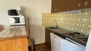 A compact kitchen with a microwave, coffee maker, sink, and dishwasher. - Cozy 2-Room Apartment for 6 in Alpe d'Huez, Ski-in/Ski-out, Near Shops, South-Facing Balcony (Huez)