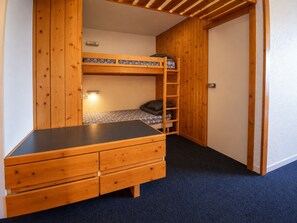 Ein Stockbett mit Schreibtisch, Schubladen, einer Leiter und einer Tür.