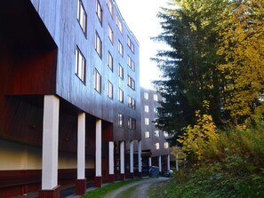Ein mehrstöckiges Gebäude mit moderner Architektur, das eine Reihe von Fenstern und einen überdachten Gang zeigt.