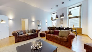 A spacious living room with two sofas, a coffee table, and pendant lights. - haussmann duplex 5br 3bth city center 225m2 (Colmar)