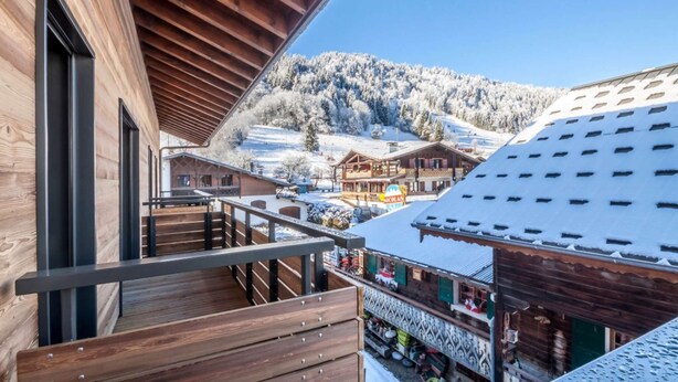 A wooden building with a balcony overlooking a snowy village and mountains. - Joux Plane A202 Beautiful central apartment 8 ppl (MORZINE)