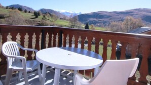 A balcony with a round table and two chairs, overlooking a mountainous landscape. - Cozy 2-Room Apartment for 6, Near Ski Lifts & Shops - L'Alpe d'Huez (Huez)