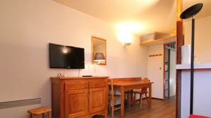 A small, cozy room with a wooden cabinet, a television, a desk, and a chair. - Cozy 2-Room Apartment for 6, Near Ski Lifts & Shops - L'Alpe d'Huez (Huez)