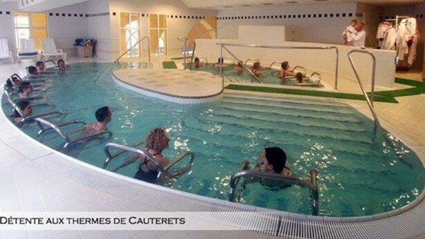 Une piscine intérieure dotée de plusieurs couloirs et d’un espace central dédié aux activités aquatiques.