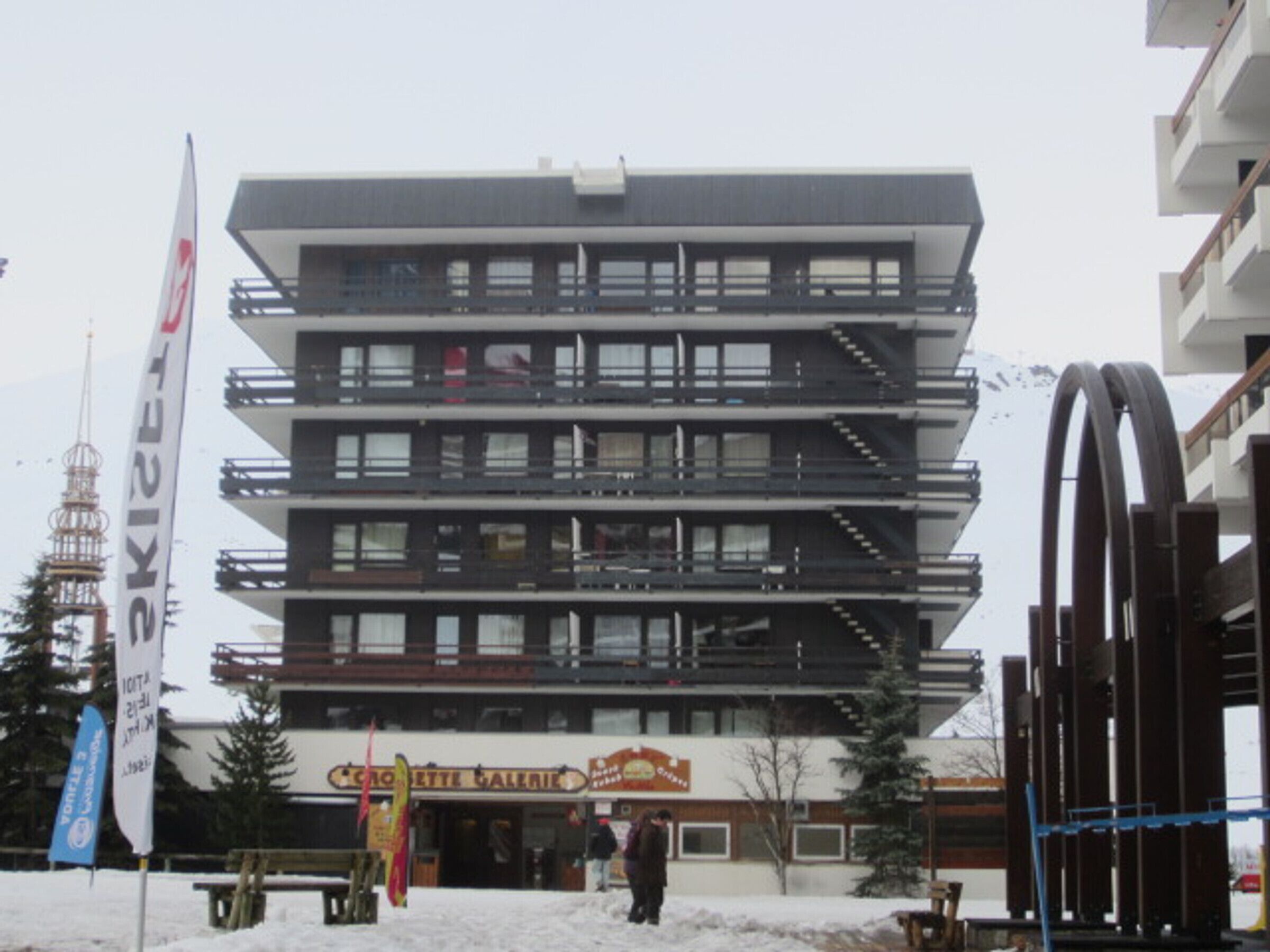 A multi-story building with balconies and a sign for "Croquette Galeries."