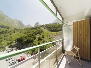 A balcony with a view of a mountainous landscape, a wooden chair, and a parking area below. - Studio for 6 people at the foot of the slopes with balcony and mountain views (Gourette)