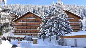 A multi-story wooden lodge with balconies, surrounded by snow-covered trees and a clear sky. - Cozy 2-Room Apt for 4, 100m from Slopes, Balcony, Pet-Friendly, WiFi - Méribel (Méribel)