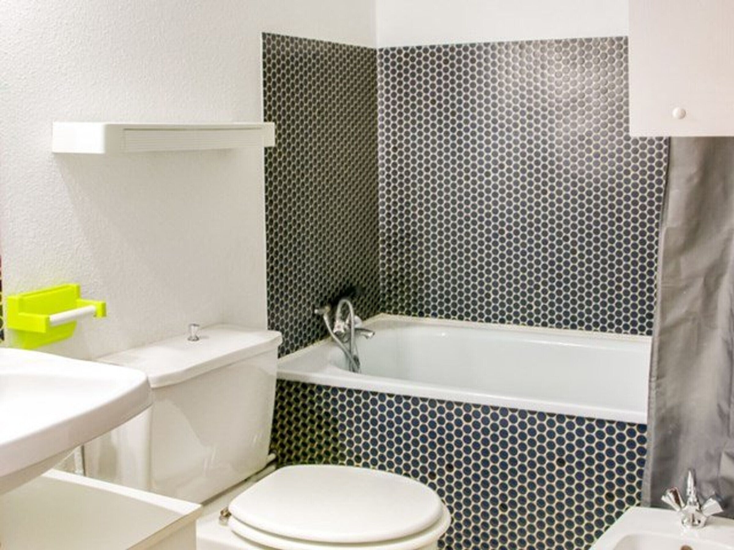 A bathroom with a toilet, sink, and bathtub.