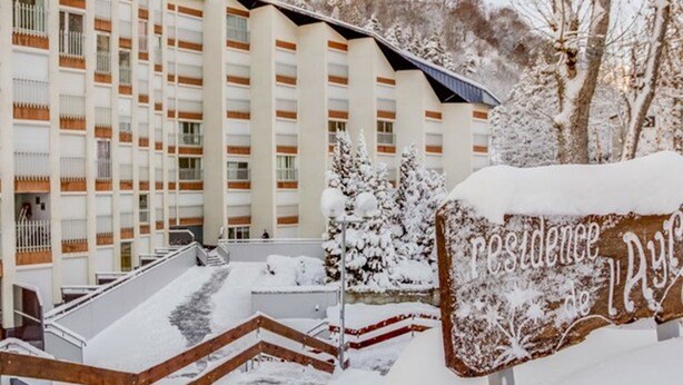 A hotel with a modern design, featuring a prominent sign with the name 'Residence de la Plagne'.