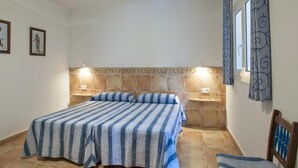 A bedroom with a bed, two bedside tables, a chair, and a decorative wall panel.