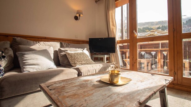 A cozy living room with a sofa, a coffee table, and a TV. - Renovated 4-room duplex, 6 pers., 2 balconies, ski locker, cleaning included (Valmorel)