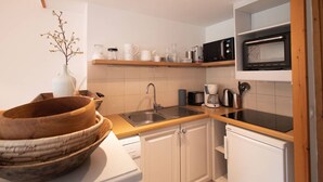 A compact kitchen with white cabinets, a wooden countertop, a sink, a microwave, and a coffee maker. - Renovated 4-room duplex, 6 pers., 2 balconies, ski locker, cleaning included (Valmorel)
