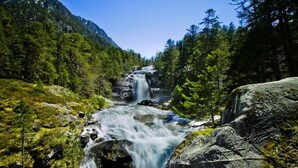 A waterfall cascading over rocks with a metal railing in the foreground. - Cozy 4-Person Apartment in Central Cauterets, Close to Ski Lift, Spa, and Amenities (Cauterets)