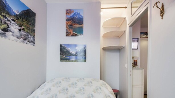 A bedroom with a bed, a small desk, and a door leading to a bathroom. - Cozy 4-Person Apartment in Central Cauterets, Close to Ski Lift, Spa, and Amenities (Cauterets)