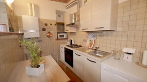 A kitchen with white cabinets, a microwave, a stove, and a dishwasher. - Casa Punta Amore - WelcHome (Cannobio)