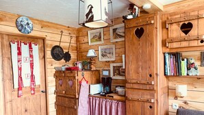Un interior acogedor de madera con cocina, una mesa de comedor y un espacio de estar con sofá.