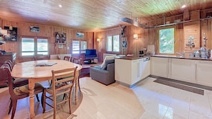 A cozy cabin interior with a dining area, sofa, TV, and kitchen. - CHALET CHEBOURINS - 8 PERS - 3 BEDROOMS - WIFI - MONTRIOND (Montriond)