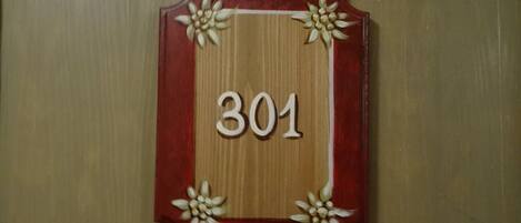 A wooden door with a red frame and the number 301.