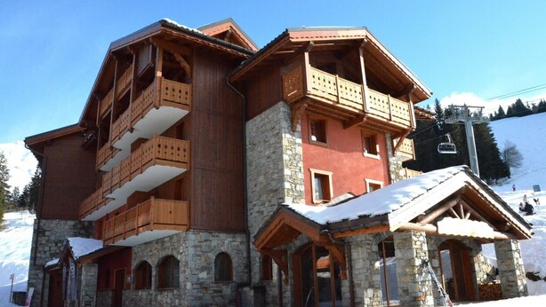 A multi-story wooden building with balconies and stone walls, surrounded by snow. - C301 - 60 m2 - 3P+Cab - 6/8 pers (Prapoutel)
