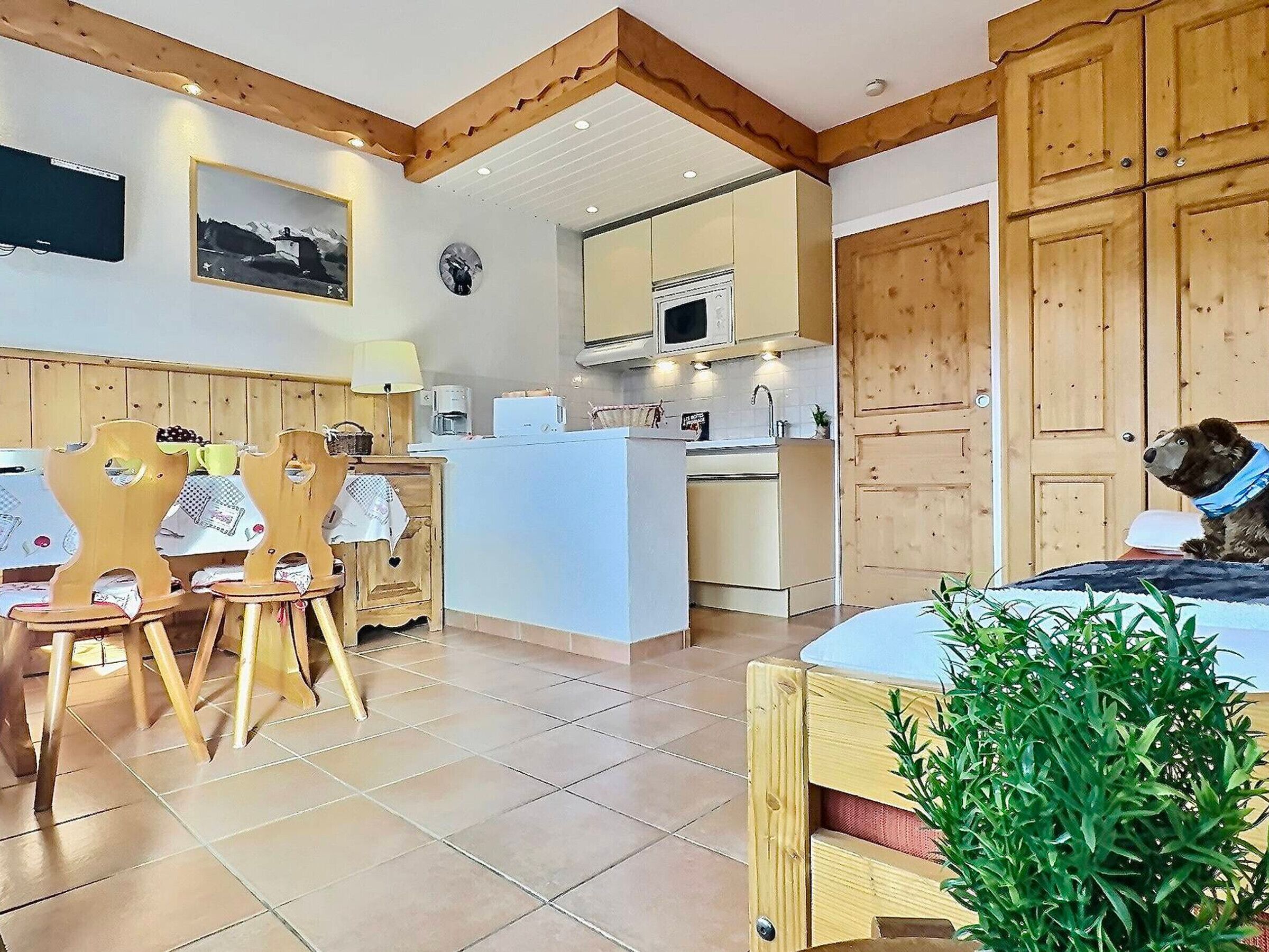 Una cucina accogliente con mobili in legno, una zona pranzo con sedie di legno e un'isola centrale.