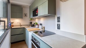 A modern kitchen with a built-in oven, a microwave, and a gas stove.