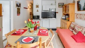 A compact living space with a dining area, kitchenette, and a bed. - Bright 2-room apt, sleeps 6, parking, near shops and skiing (Barèges)
