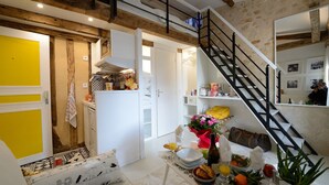 Una cocina moderna con armarios blancos, horno empotrado y una puerta amarilla.