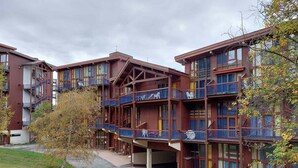 A multi-story building with balconies, a covered walkway, and a grassy area in front. - 3-room duplex sleeps 6 near slopes in Arc 1800 (Les Arcs 1800)