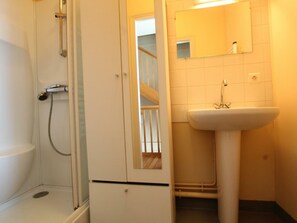 Ein Badezimmer mit Dusche, Waschbecken und Spiegel.
