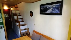 A room with a wooden table and bench, a staircase, and a framed picture on the wall. - Duplex studio 5 pers. with SW-facing balcony in Arcs 1800 (Les Arcs 1800)