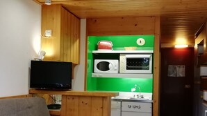 A compact kitchen with a microwave, toaster, and sink. A television is mounted on the wall above the counter. - Duplex studio 5 pers. with SW-facing balcony in Arcs 1800 (Les Arcs 1800)