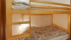 A bunk bed with a patterned blanket and a pillow. - Comfortable studio with parking in Grand Bornand (Le Grand-Bornand)