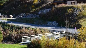 Un puente sobre un río con un muro de piedra y vegetación a los lados.