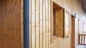 A wooden cabin with a window and a door, a concrete floor, and a metal grate. - Cozy Studio, Ski-In/Ski-Out, Near Shops & Restaurants, Méribel Centre (Méribel)