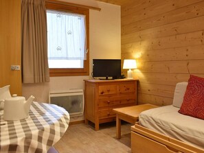 Une pièce confortable avec un lit, un bureau équipé d’un ordinateur, une table et une fenêtre avec des rideaux.